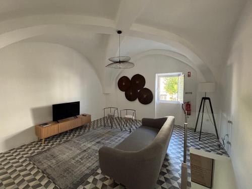 a living room with a couch and a television at QO - Terrace Suites in Vila Viçosa