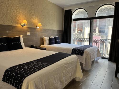 a hotel room with two beds and a window at Hotel Del Portal, Puebla in Puebla