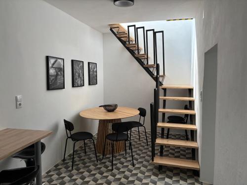 a room with a table and a spiral staircase at QO - Terrace Suites in Vila Viçosa