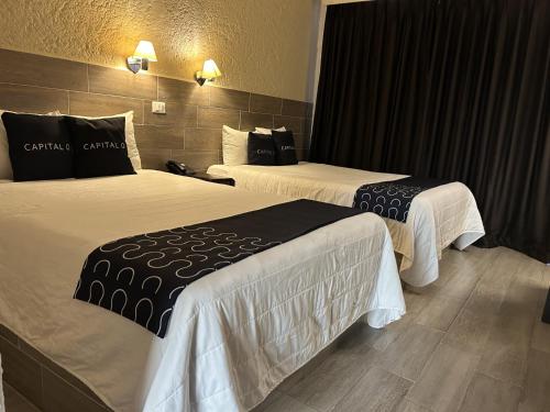 a hotel room with two beds with black and white sheets at Hotel Del Portal, Puebla in Puebla
