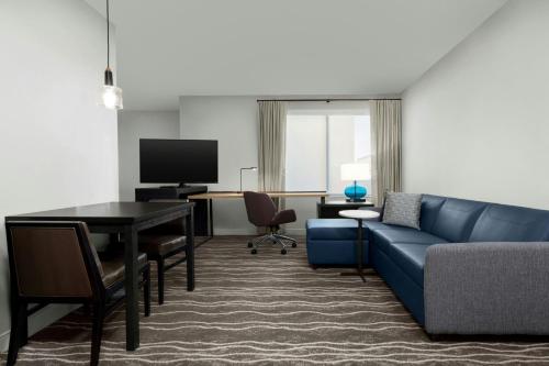 a living room with a blue couch and a table at Residence Inn by Marriott Sacramento Cal Expo in Sacramento