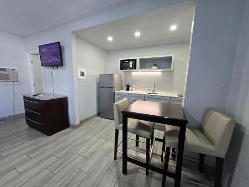 a living room with a table and a kitchen at Ocean Holiday Motel in Daytona Beach
