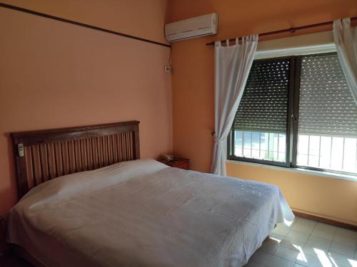 ein Schlafzimmer mit einem Bett und einem großen Fenster in der Unterkunft El rancho e Matias in Villa Lía