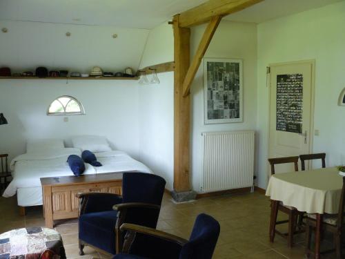 a bedroom with a bed and a table and chairs at De Bekboer in Losser