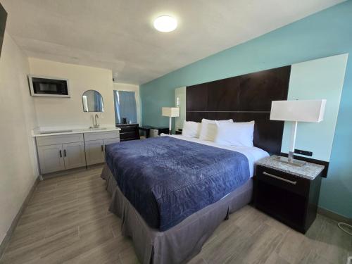 a hotel room with a large bed and a sink at Ocean Holiday Motel in Daytona Beach