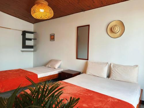 a room with two beds and a plant at La Chiva Hostal Armenia in Armenia