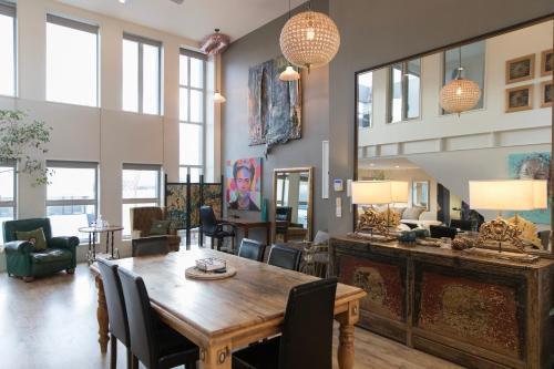 クライストチャーチにあるHuge Stylish Art Loft with Spa & Soaring Ceilingsの木製のテーブルと椅子のあるリビングルーム
