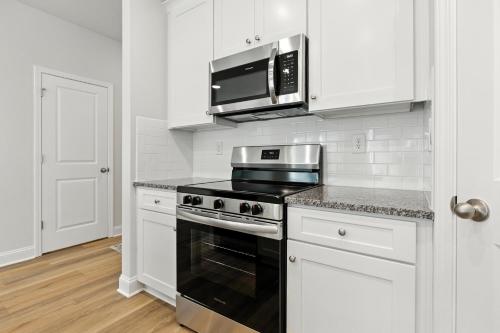 a kitchen with a stove and a microwave at Charming Easley Retreat with Private Yard townhouse in Easley