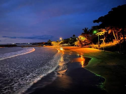 a beach at night with lights on the shore at Blanca House in Arboletes