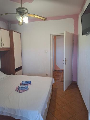 a bedroom with a white bed and a door at Sukošan - Zadar in Sukošan