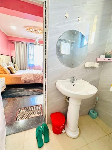 a bathroom with a sink and a mirror and a bed at Elegant & Modern 3-Bedroom Apartment Central Downtown Escape in Dar es Salaam