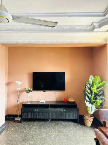 a living room with a flat screen tv on a wall at Elegant & Modern 3-Bedroom Apartment Central Downtown Escape in Dar es Salaam