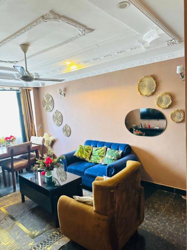 a living room with a blue couch and a table at Elegant & Modern 3-Bedroom Apartment Central Downtown Escape in Dar es Salaam