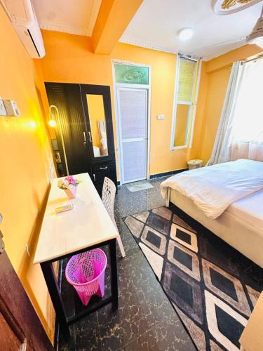 a room with a bed and a table and a bed and a desk at Elegant & Modern 3-Bedroom Apartment Central Downtown Escape in Dar es Salaam
