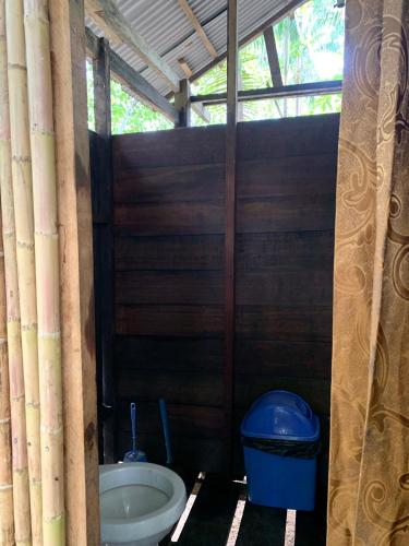 a small bathroom with a toilet and a trash can at Oropendola Expeditions in Tambopata
