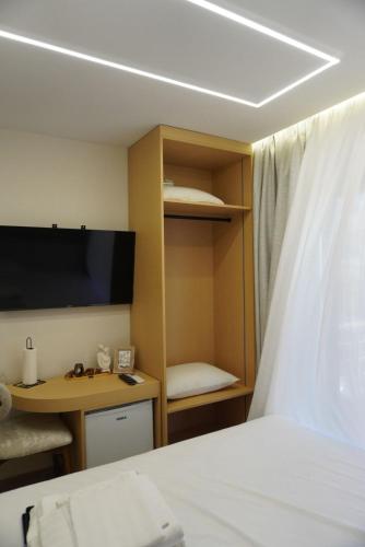 a bedroom with a bed and a desk and a tv at Ionian Blue Apartament 5 in Himare