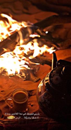 a fire pit with a cup of tea next to it at Wadi Rum Adventures in Aqaba
