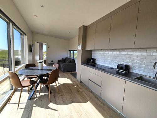 a kitchen and dining room with a table and chairs at Hítarneskot Accommodations in Hítarneskot