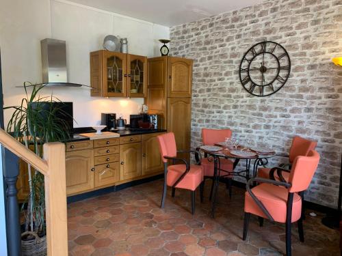 une cuisine avec une table, des chaises et un comptoir dans l'établissement La Meunière, à Jouy