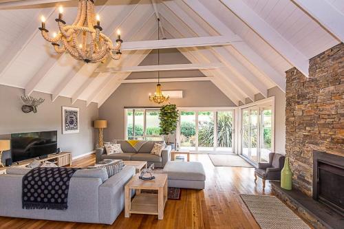 a living room with a stone fireplace and a chandelier at Benwerrin House Fish Creek in Fish Creek