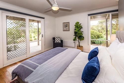 a bedroom with a large bed with blue pillows at Benwerrin House Fish Creek in Fish Creek