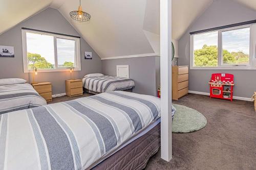 a attic bedroom with two beds and two windows at Benwerrin House Fish Creek in Fish Creek
