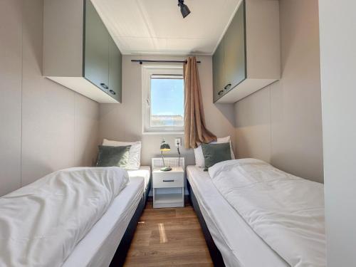 two beds in a small room with a window at Fuut 24-28 in Breukelen
