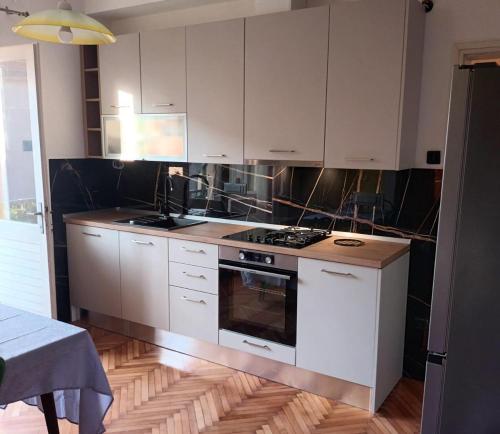a kitchen with white cabinets and a stove top oven at Apartments and rooms by the sea Jelsa, Hvar - 4602 in Jelsa