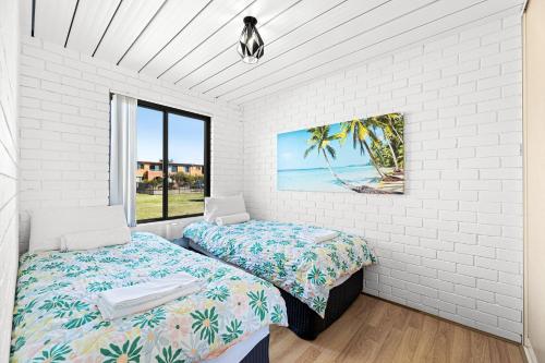 a bedroom with two beds and a window at Apollo Unit 25 Ground Floor in Narooma
