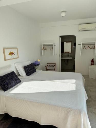 a bedroom with a large white bed with two pillows at Baía das Caldeirinhas in Horta