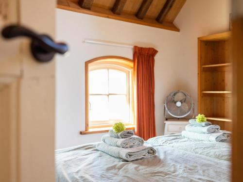 a bedroom with towels on a bed with a window at Het Koetshuis in Zurich