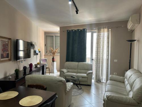 a living room with a couch and chairs and a table at Turdiu center apart in Tirana
