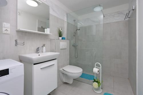 a white bathroom with a toilet and a shower at Apartments with parking space Dramalj, Crikvenica - 5592 in Dramalj