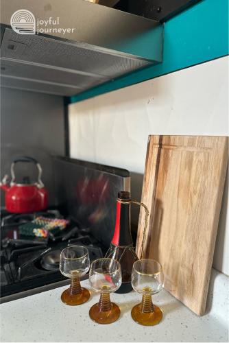 two wine glasses sitting on a counter next to a stove at Friendly Suite Home Chicago in Berwyn