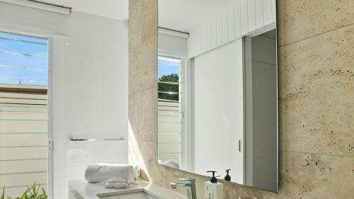a bathroom with a mirror and a sink at Casa Lux- Infared Sauna and heated magnesium pool in Kingscliff