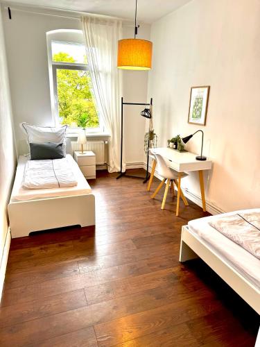 a bedroom with two beds and a desk and a window at K-Apartments No 1 Ferienwohnung Monteurwohnung 1-5 Personen in Braunschweig