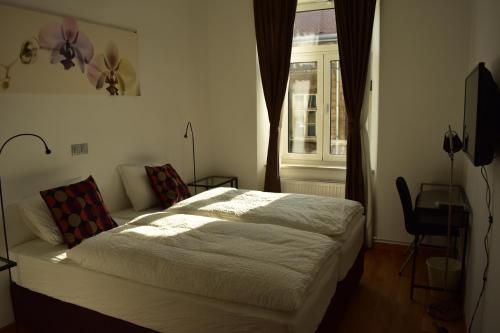 a bedroom with a white bed and a window at B&B Cool Centre Zagreb in Zagreb