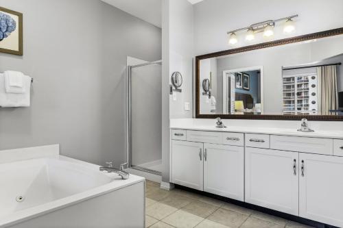 a white bathroom with two sinks and a large mirror at Club Wyndham at Majestic Sun in Destin