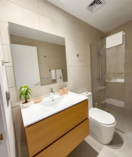 a bathroom with a sink and a toilet and a mirror at Gardenia in Punta Cana