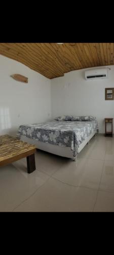 a bed in a room with a wooden ceiling at Casa Peninsula de Maraú in Marau
