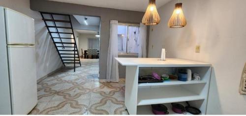 a kitchen with a white counter and a staircase at Departamento PL in Paso de los Libres