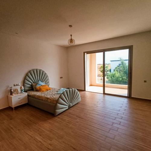 a bedroom with a bed in a room with a large window at Villa in Meknès