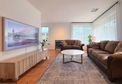 Clarendonにある4BR Retreat Near McLaren Vale Wineries Adelaideのソファとテーブルのあるリビングルーム