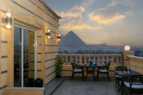 a balcony with a table and a view of the pyramids at Crowne Pyramids View inn in Cairo