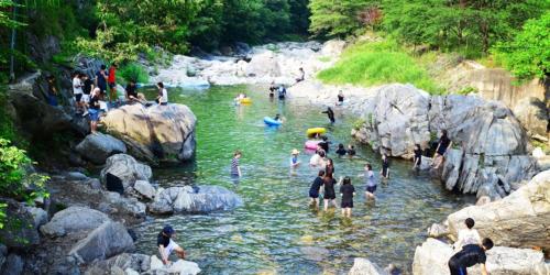 a group of people swimming in a river at Pung Gyeong Sori Pension in Gapyeong