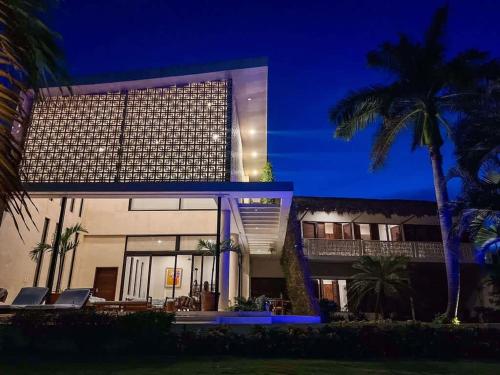 a building with palm trees in front of it at 7BR Beautiful Waterfront Villa - Perfect Getaway in Calderitas