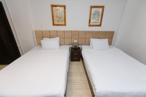 two beds sitting next to each other in a room at Crowne Pyramids View inn in Cairo