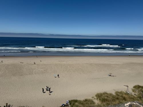 a group of people on a beach near the ocean at Seahorse Oceanfront Lodge in Lincoln City