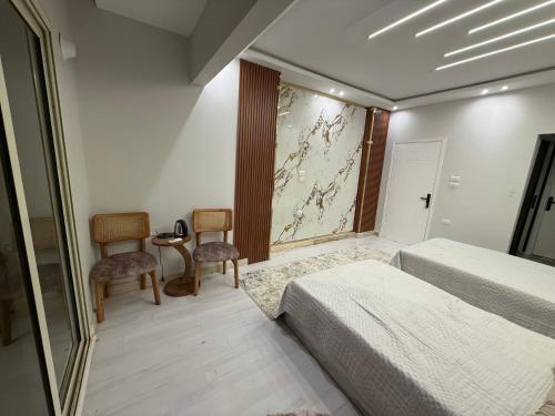 a bedroom with two beds and two chairs and a mirror at Down town 2 in Cairo