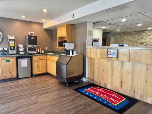 a kitchen with wooden cabinets and a counter with a refrigerator at FairBridge Inn Express Billings Airport in Billings